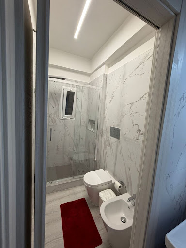 Bagno moderno con rivestimento effetto marmo e lavabo con specchio